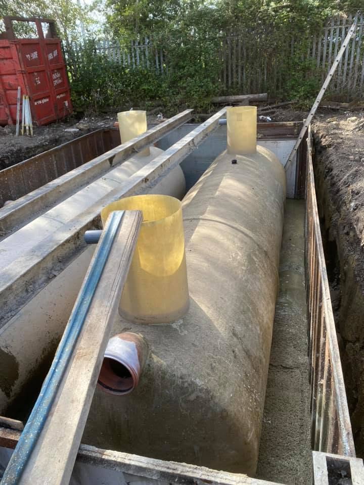 Precast concrete interceptor tank being installed in a trench