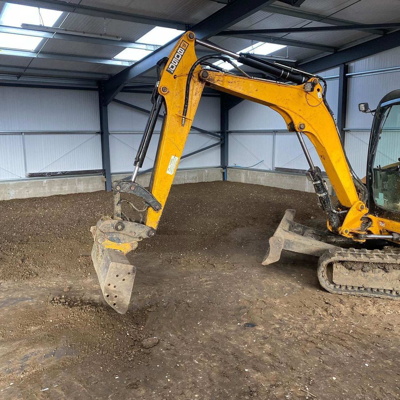 Mini excavator working inside a steel-frame building