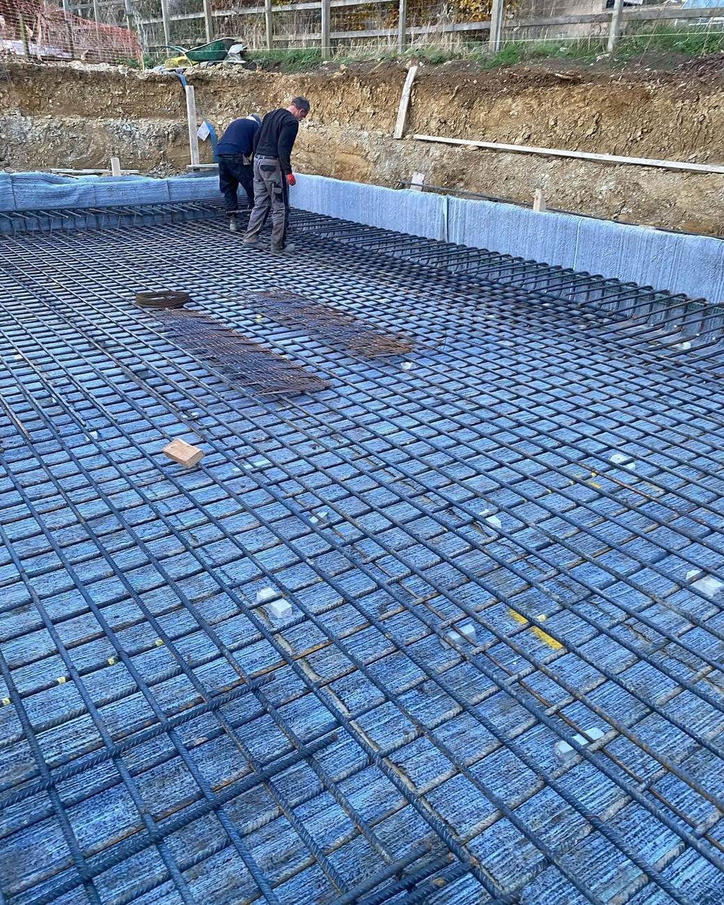 Swimming pool base with reinforcement mesh and waterproof membrane